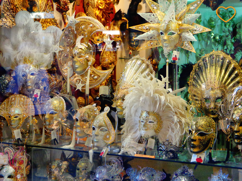 Foto de uma vitrine com muitas máscaras típicas do famoso carnaval de Veneza.
