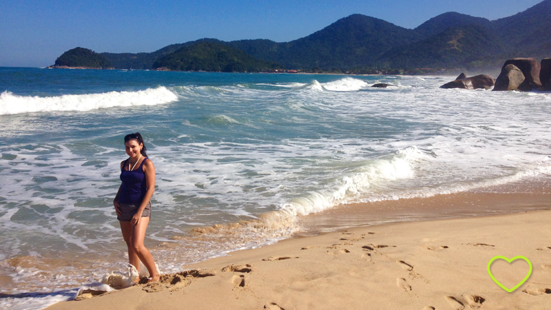 O mar, bem azul, muitas ondas, montanhas ao fundo que, por estarem longe, se vêem azuladas, "esculturas" feitas pela erosão perto do mar, eu posando e molhando os pés no mar.