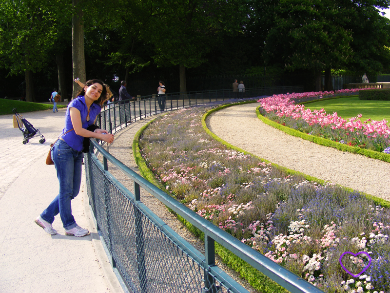 Eu ao lado de um jardim com flores.