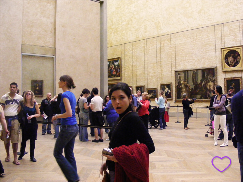 Foto minha no Louvre. Vê-se a Monalisa ao fundo.