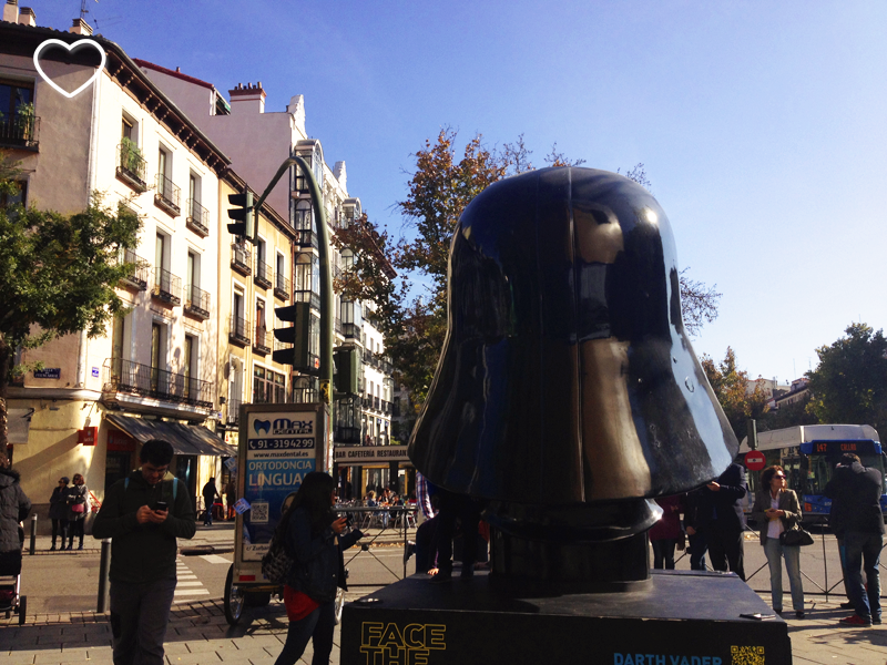 O capacete de Darth Vader, de costas. Ao fundo, edifícios.