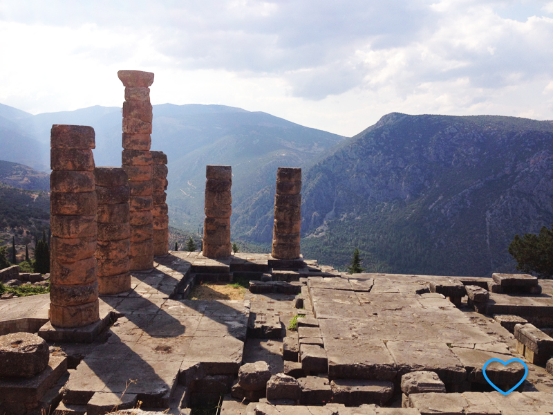 As ruínas do templo com suas colunas e as montanhas ao fundo.
