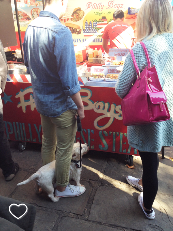 Um casal espera pelo seu lanche em uma barraquinha no Camden Market. O cachorro deles, sentado, parece ter esperança de algo.